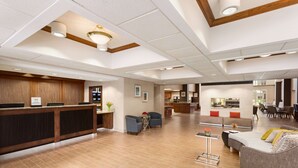 A spacious lobby with a reception desk, seating area, and a dining area.
