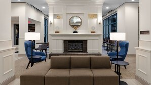 A lobby with a fireplace, a large mirror, and seating areas. - Hilton Garden Inn Atlanta Perimeter Center (Atlanta)