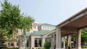 Un hôtel Hilton Garden Inn doté d’une entrée abritée, de grandes fenêtres et d’un toit végétalisé.