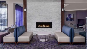 A modern living room with two sofas, a fireplace, and a patterned carpet. - Hilton Garden Inn Calgary Airport (Calgary)