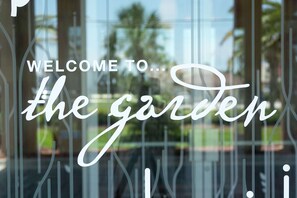 A glass door with the text "WELCOME TO the garden" written on it. - Hilton Garden Inn St. Augustine Beach (St. Augustine)