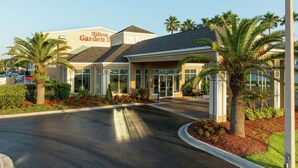A hotel entrance with a palm tree-lined driveway, a clear sky, and a sign reading "Hilton Garden Inn". - Hilton Garden Inn St. Augustine Beach (St. Augustine)