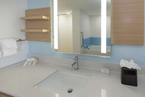 A bathroom with a large mirror, a sink, and a towel rack. - Hilton Garden Inn St. Augustine Beach (St. Augustine)