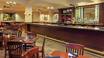 A restaurant with wooden tables and chairs, a bar area, and ceiling fans.