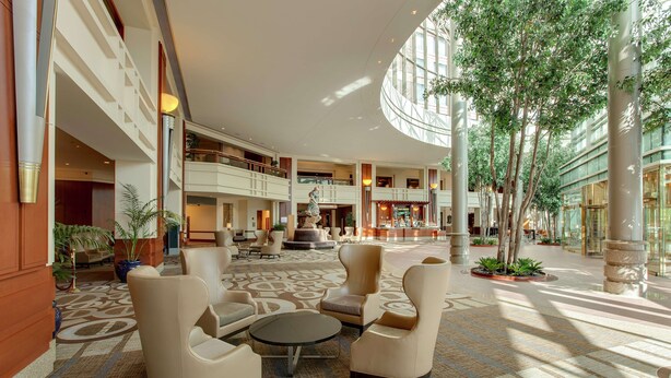 A spacious lobby with a central seating area, multiple levels, and a fountain.