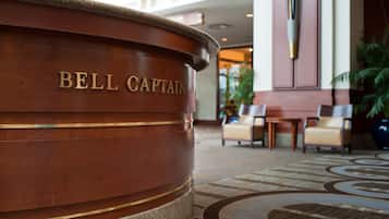 En receptionsdisk i trä med inskriptionen ”BELL CAPTAIN” i en hotellobby.