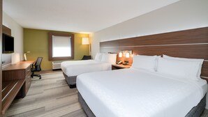 A hotel room with two beds, a desk, a chair, and a TV.
