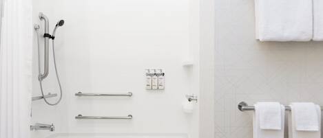 A modern bathroom with a bathtub, shower, and towel rack.