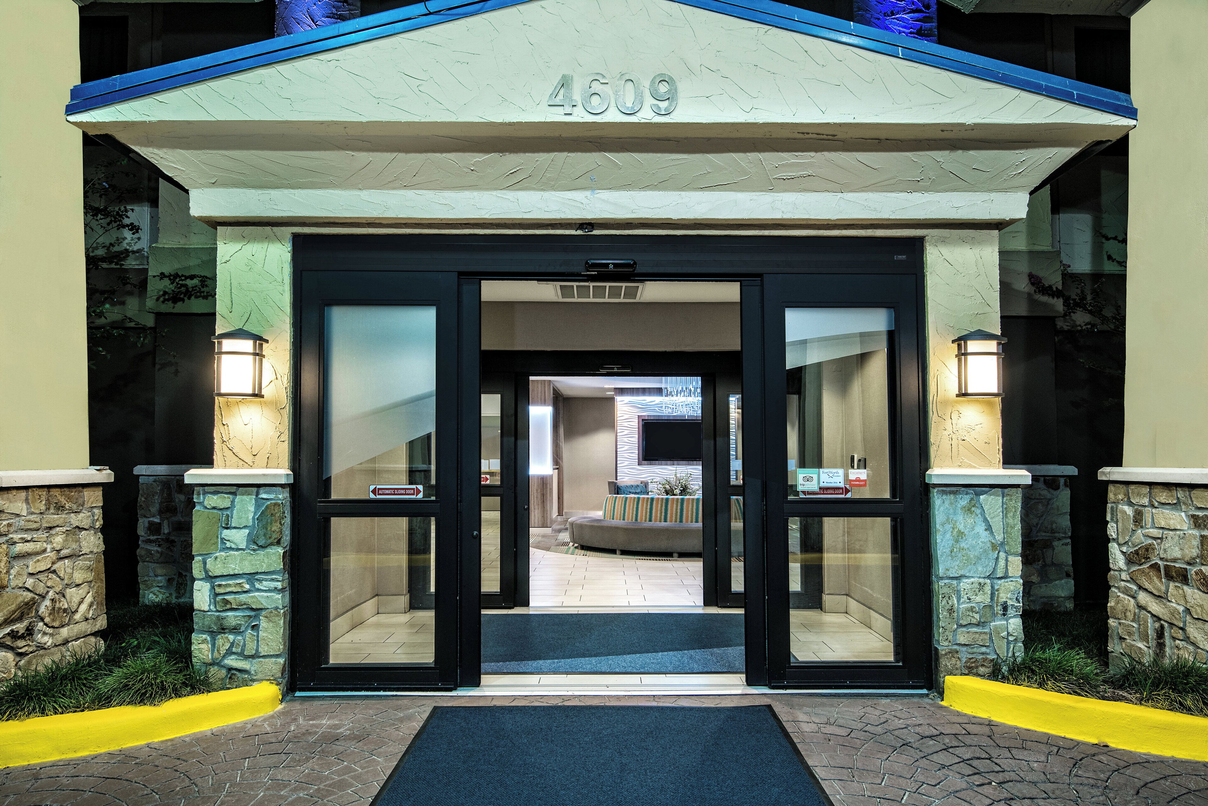 A hotel entrance with a number '4609' above the doors, automatic sliding doors, and a stone facade.