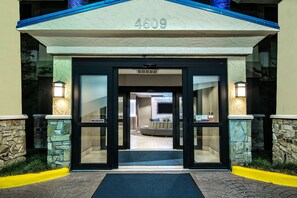 L’entrée d’un hôtel, avec une façade en pierre, le numéro 4609, et une porte en verre donnant sur l’intérieur.