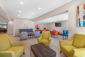 Un intérieur moderne avec des coins salon, un téléviseur à écran plat et des œuvres d’art accrochées aux murs.