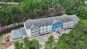 Un hôtel à plusieurs étages, doté d’un toit plat, d’une façade bleue et blanche et d’une installation de panneaux solaires.