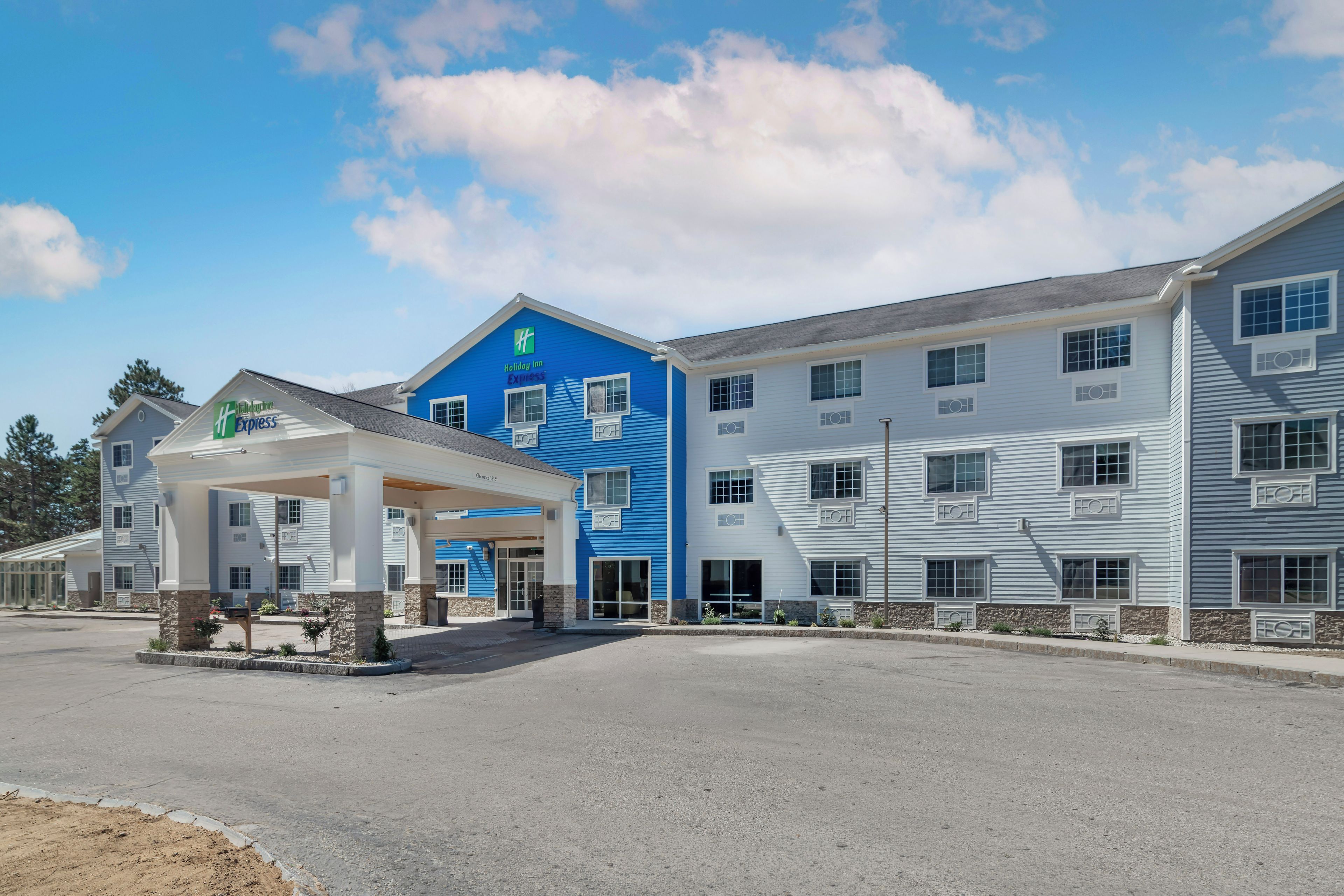 Un bâtiment de l’hôtel Holiday Inn Express doté d’un espace extérieur abrité et surplombant un ciel dégagé.