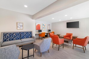 A modern lounge area with a sofa, armchairs, a small table, and a flat-screen TV mounted on the wall. - Holiday Inn Express North Conway by IHG (North Conway)
