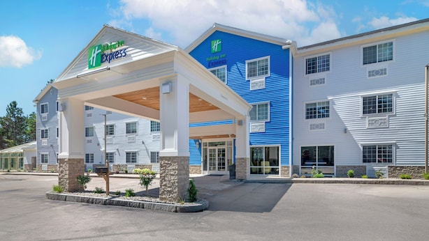 Un hotel Holiday Inn Express con entrada cubierta y fachada azul.