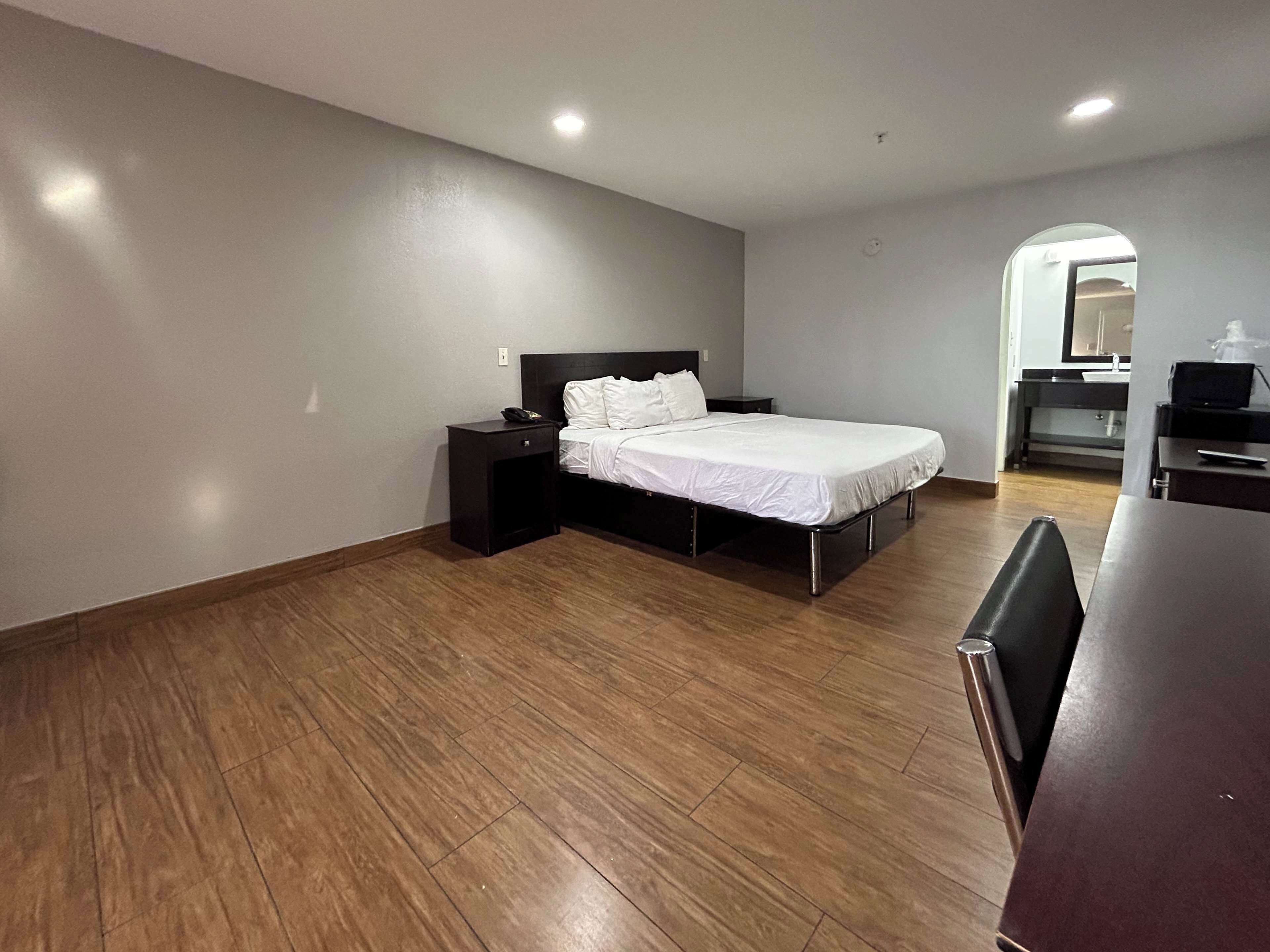 A hotel room with a bed, a desk, and a chair.