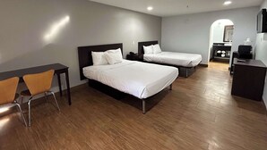 A hotel room with two beds, a desk, and a chair.