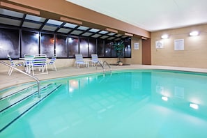 An indoor swimming pool with clear water, surrounded by lounge chairs and a potted plant. - Holiday Inn Express & Suites Alcoa (Knoxville Airport) by IHG (Alcoa)