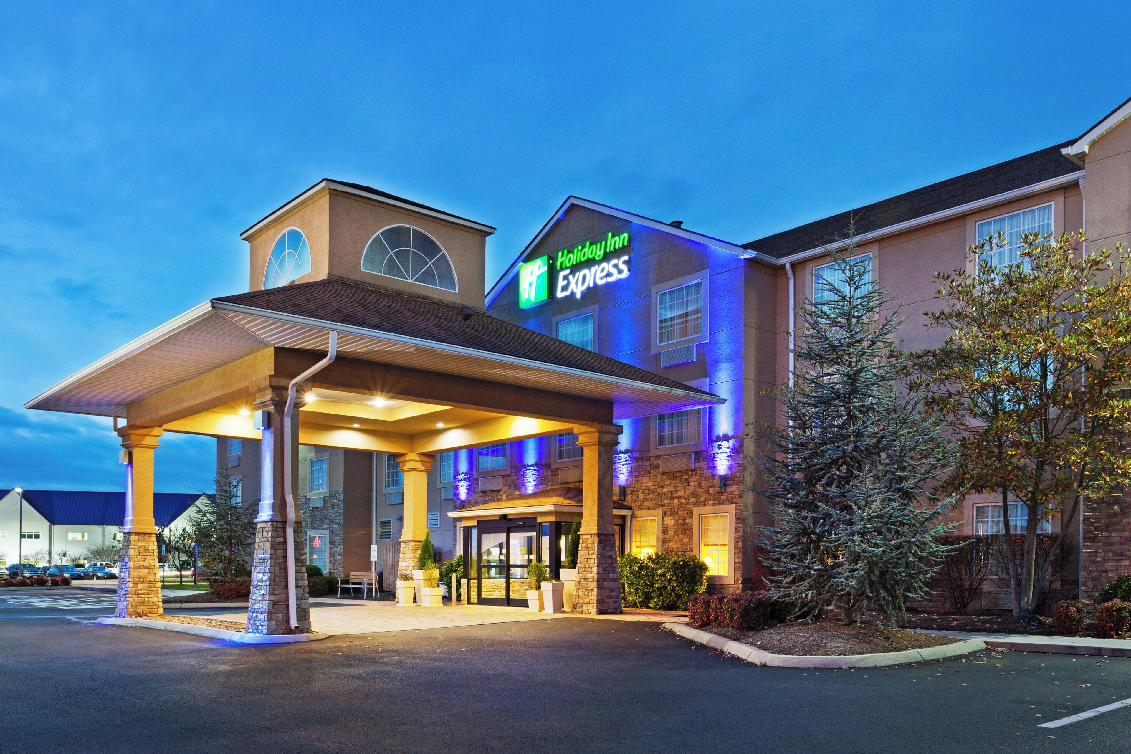 A Holiday Inn Express hotel with a covered entrance, stone pillars, and a parking lot.
