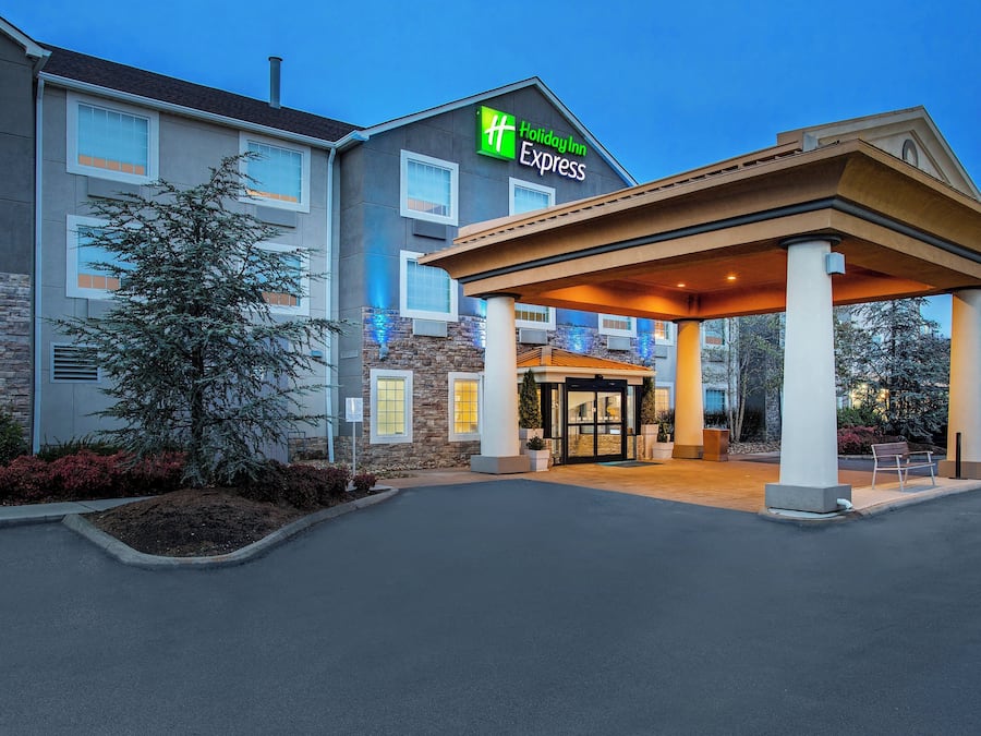 A Holiday Inn Express hotel with a covered entrance, stone facade, and a parking lot.