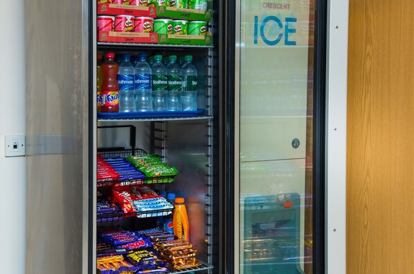 Distributore automatico pieno di bevande e snack assortiti.