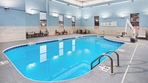 An indoor swimming pool with clear water, tiled edges, and a lifeguard stand. - Holiday Inn Express Cleveland Airport - Brookpark by IHG (Brook Park)