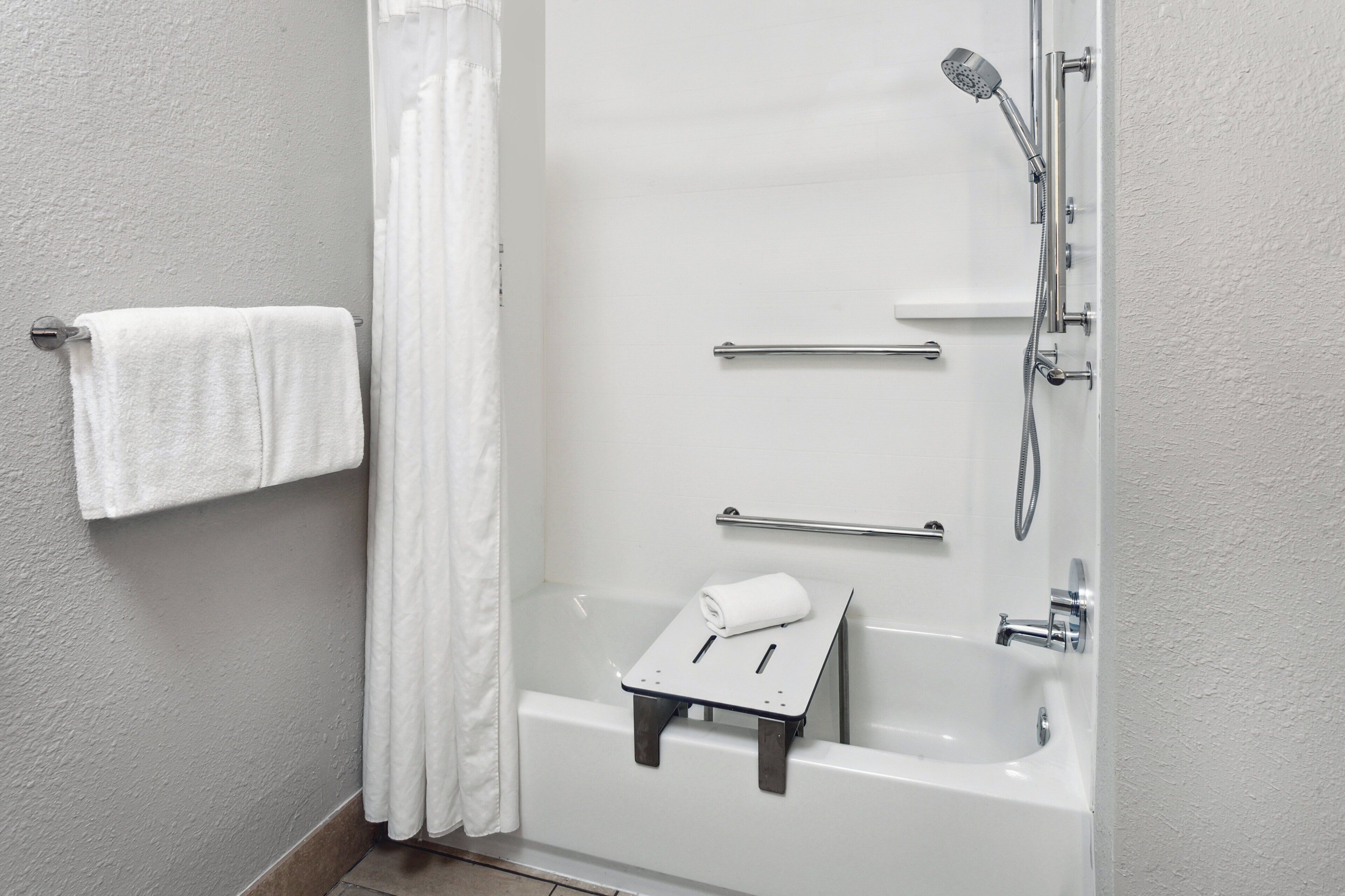 Un baño moderno con bañera, ducha y toallero.