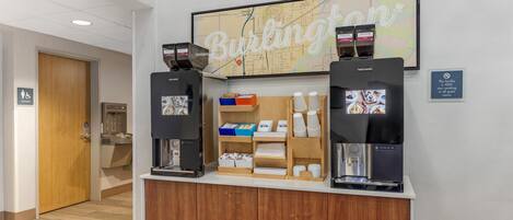 A coffee station with two coffee dispensers, a map on the wall, and a sign indicating the facility is non-smoking.