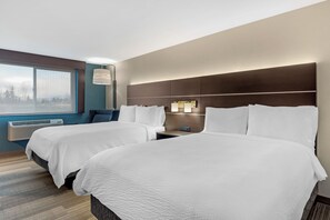 Une chambre d’hôtel avec deux lits, une grande fenêtre, un appareil de climatisation et une table de chevet avec une lampe.