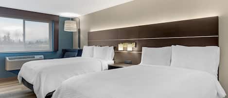 A hotel room with two beds, a large window, an air conditioning unit, and a nightstand with a lamp.
