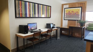 A small office with a desk, two chairs, a computer, and a printer. There is a trash can and a plant on the desk. - Holiday Inn Express & Suites Burlington by IHG (Burlington)