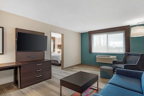 A hotel room with a flat-screen TV, a desk with drawers, a sofa, a coffee table, and a large window with a view. - Best Western Plus Burlington Skagit Valley Inn (Burlington)