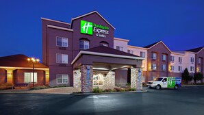 Edificio de Holiday Inn Express & Suites con un diseño moderno, que cuenta con una entrada destacada y un estacionamiento.