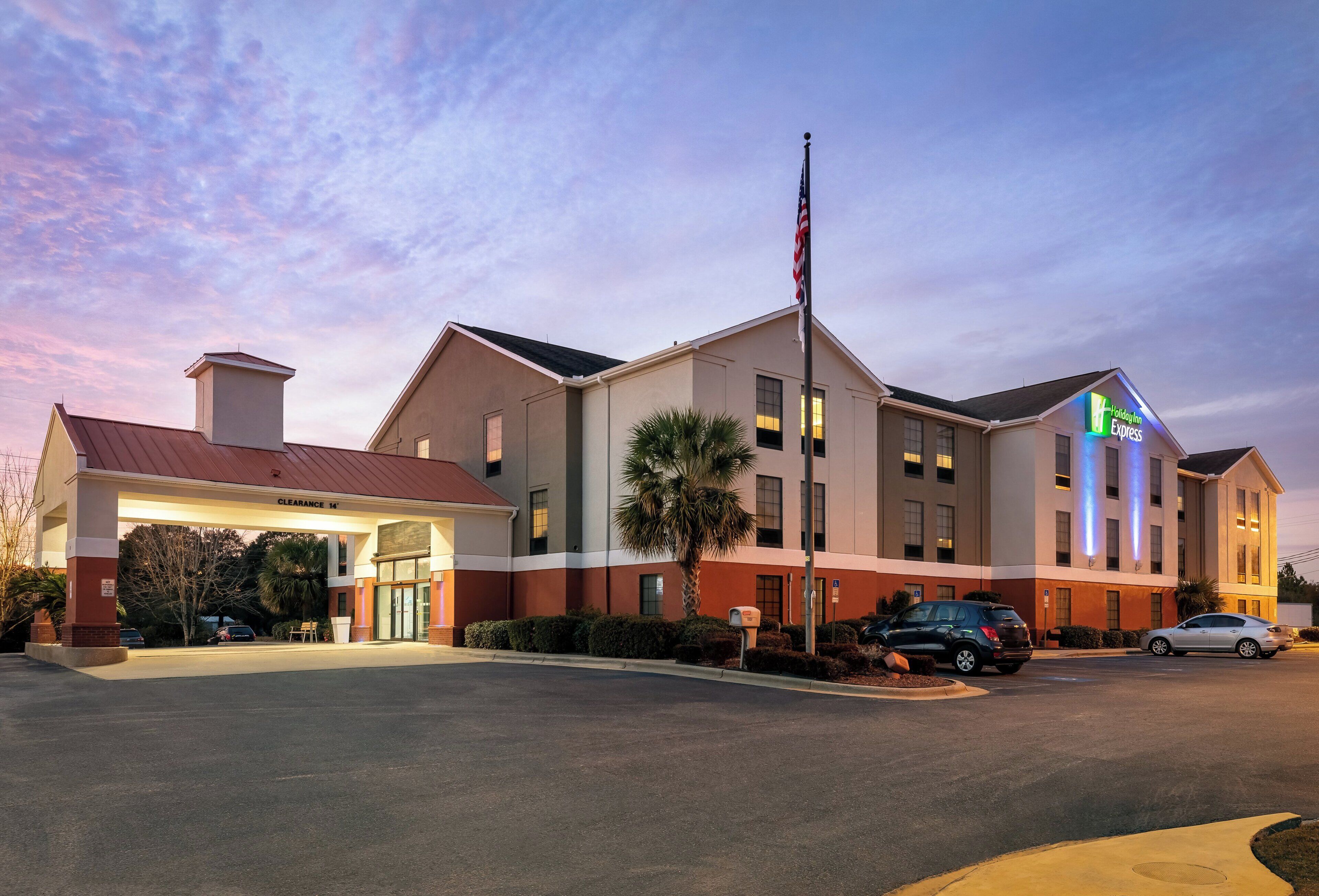 A hotel with a clear entrance, a flagpole, and a Holiday Inn Express sign.