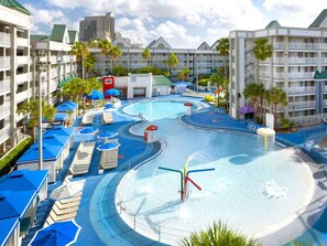 A hotel with multiple swimming pools, sun loungers, and a water slide.
