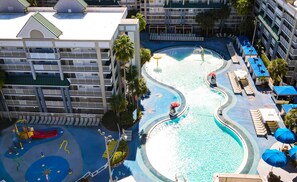 A hotel with a large pool area, including a children's play area and multiple lounge chairs. - Holiday Inn Resort Orlando Suites - Waterpark by IHG (Orlando)