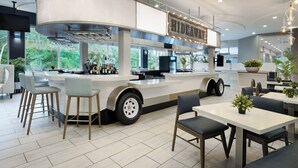 A modern kitchen with a curved island, bar area, and seating for guests. - Holiday Inn Resort Orlando Suites - Waterpark by IHG (Orlando)