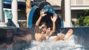 A person in a water slide with a blue arch structure. - Holiday Inn Resort Orlando Suites - Waterpark by IHG (Orlando)