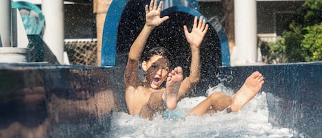 A person in a water slide with a blue arch structure.
