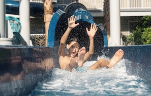 A person in a water slide with a blue arch structure. - Holiday Inn Resort Orlando Suites - Waterpark by IHG (Orlando)