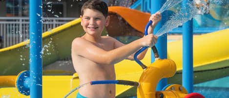A child playing with a water pump at a water park.