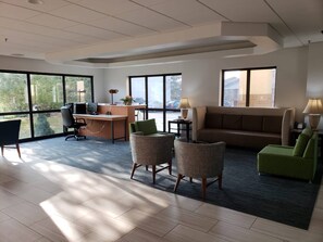A modern hotel room with a desk, office chair, sofa, two armchairs, and a large window offering a view of the outdoors. - Holiday Inn Express Edgewood-Aberdeen-Bel Air by IHG (Edgewood)