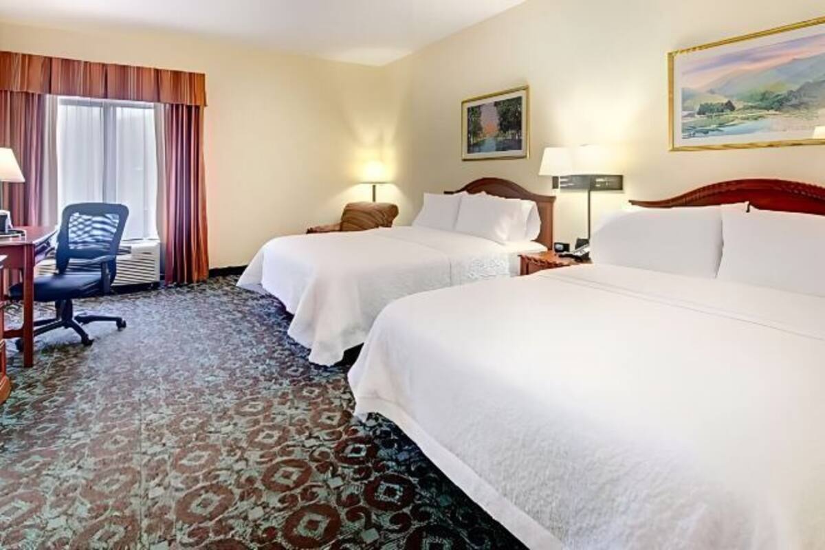 Camas com colchões pillow-top, escrivaninha, cortinas blackout