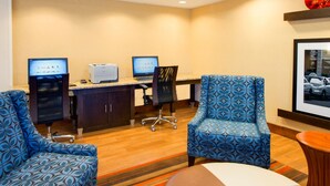 A conference room with two desks, two chairs, and a small table.