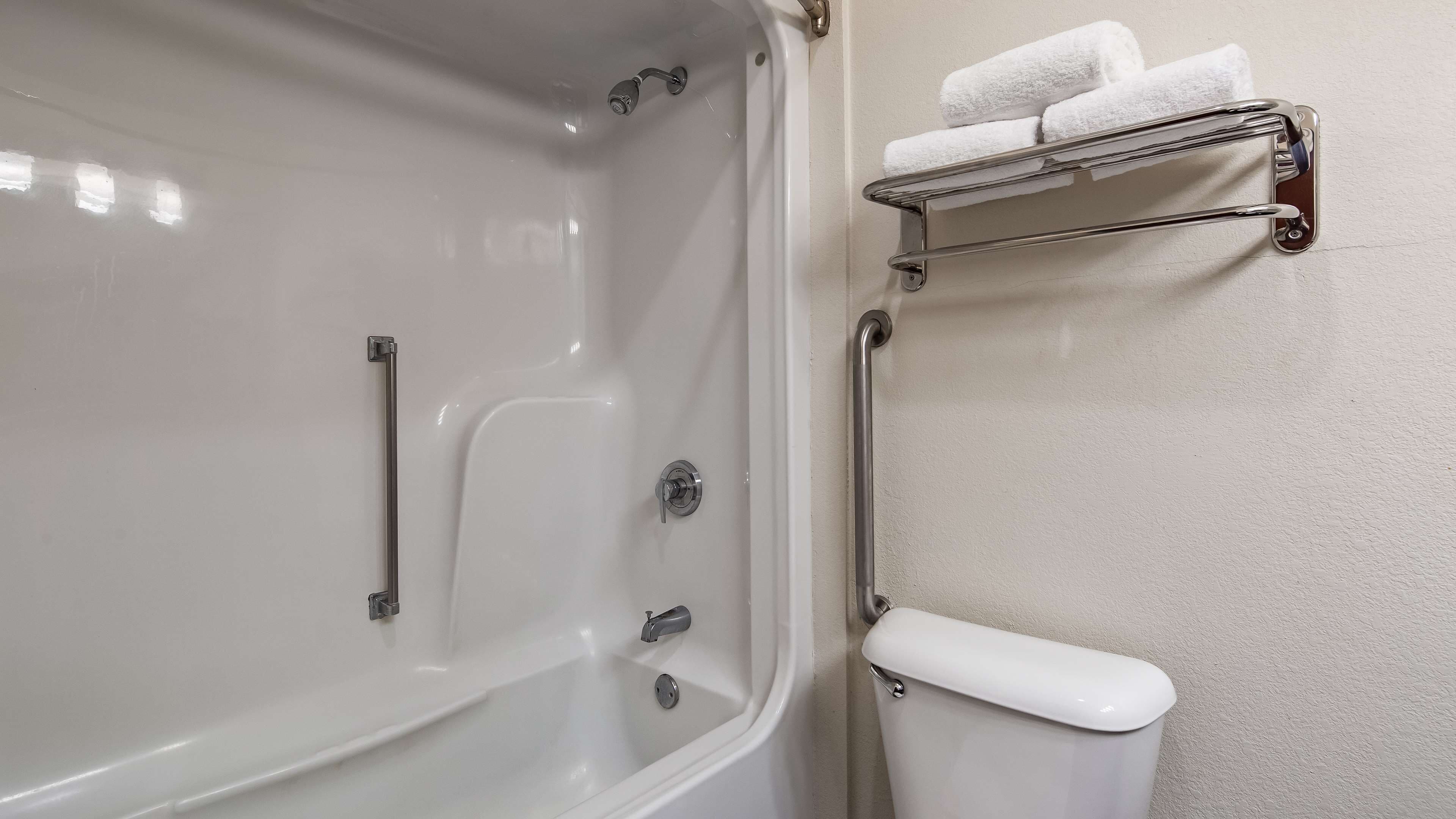 Une salle de bain équipée d’une baignoire, de toilettes et d’un porte-serviettes avec des serviettes.