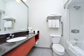 Une salle de bain moderne équipée d’un lavabo, de toilettes et d’une douche.
