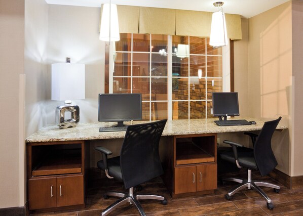 A workspace with two desks, each with a computer, chairs, and a cabinet.