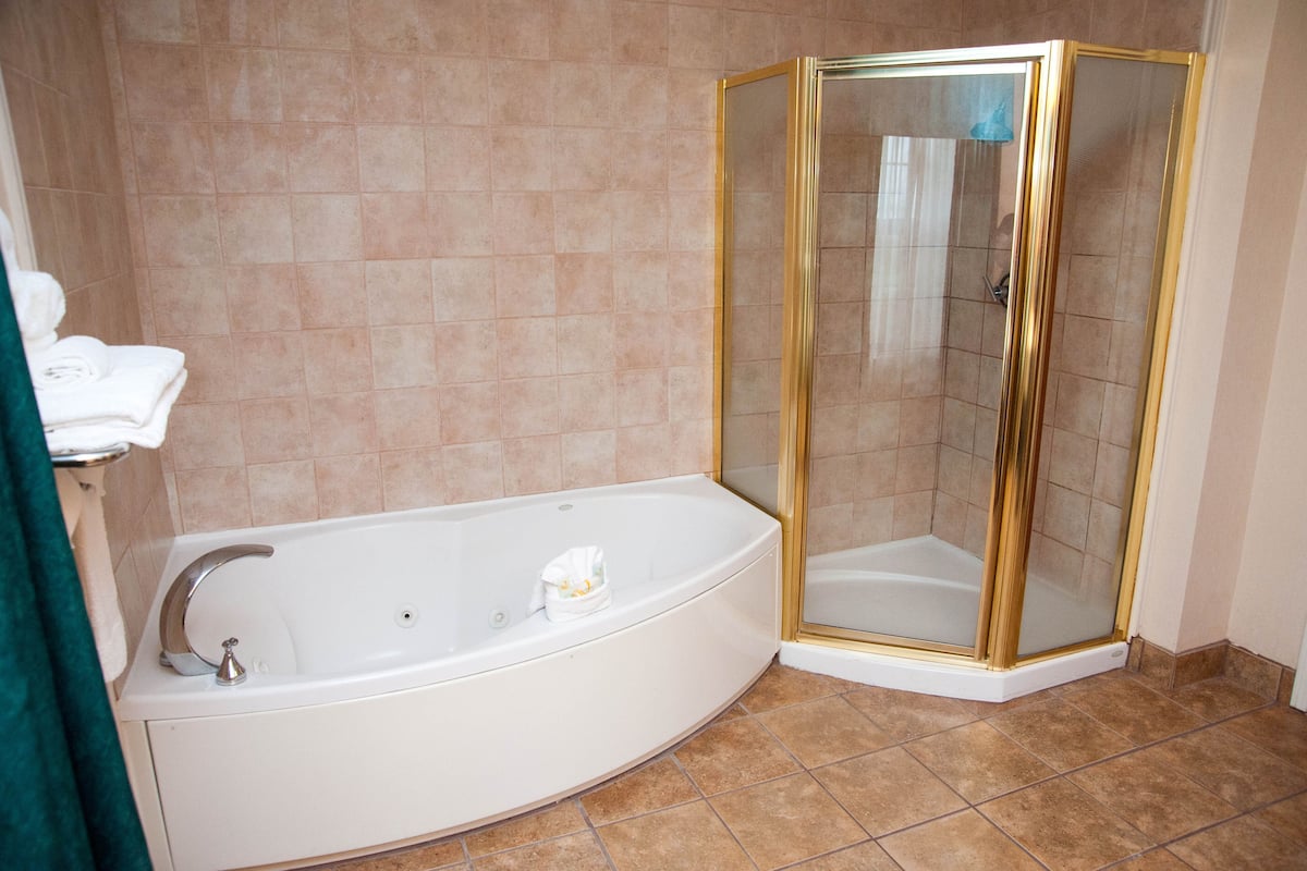 suite, 1 king bed, jetted tub | bathroom | combined shower/bathtub, designer toiletries, hair dryer, towels