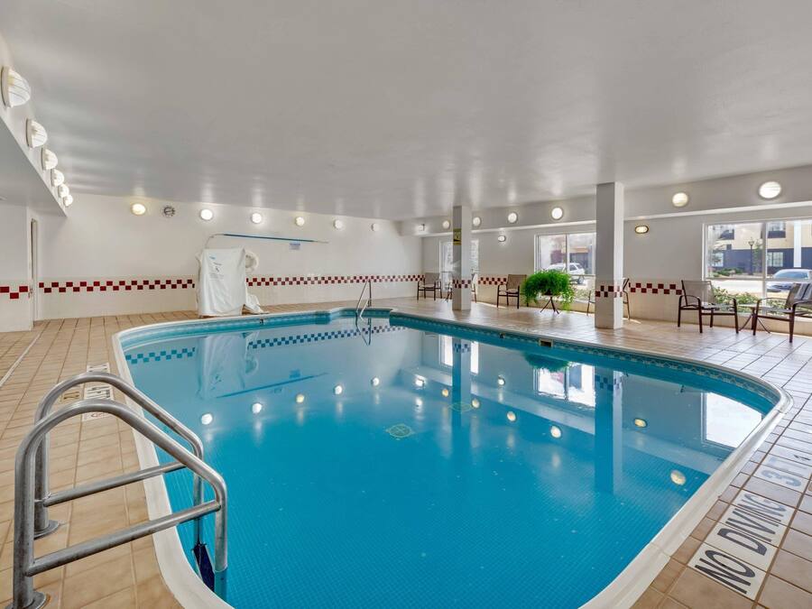 A large indoor swimming pool with a tiled floor, a ladder, and a 'NO DIVING' sign.