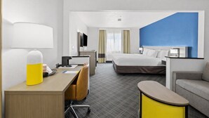 Ein Hotelzimmer mit Bett, Schreibtisch, Stuhl und einem kleinen Tisch.